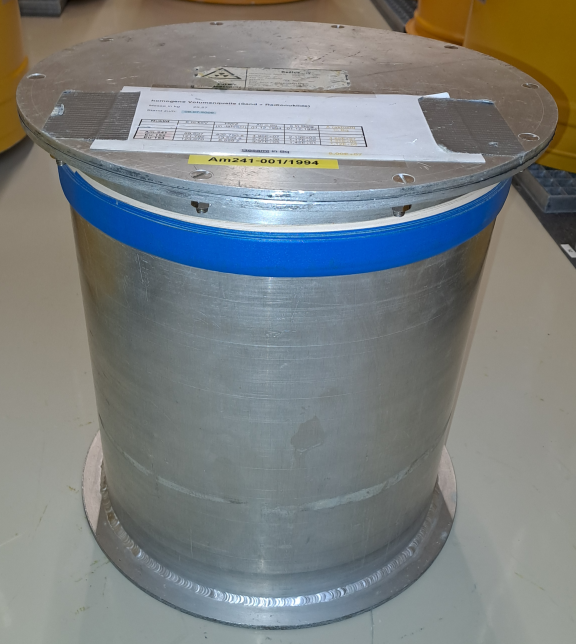 Foto einer Volumenquelle (Abmessungen: Höhe:. 36,5 cm Durchmesser: ca. 35,0 cm; Masse: 4733 g; Aluminium-Behälter; Matrix: Sand; Radionuklide: 152-Eu, 15-4Eu, 241-Am).
