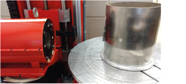 Foto einer Messanordnung zur Bestimmung der Detektoreffektivität mit einer Punktquelle (befindet sich rechts am Aluminiumzylinder). Der Detektor befindet sich in einem zylindrischen Kollimator. Der Öffnungswinkle ist aber so groß, dass das gesamte spätere Messobjekt, das die gleiche Form wie das gezeigt Dummy-Objekts hat, erfasst wird.